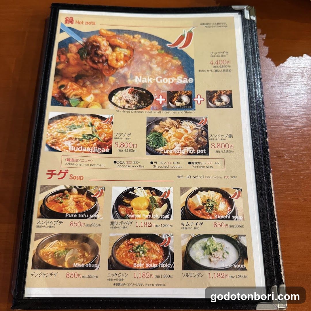 A Japanese restaurant menu featuring hot pot dishes, including Nak-Gop-Sae (stir-fried octopus), Buda-ejiigae, Pure tofu hot pot, and various soups like Kimchi soup and Beef soup.