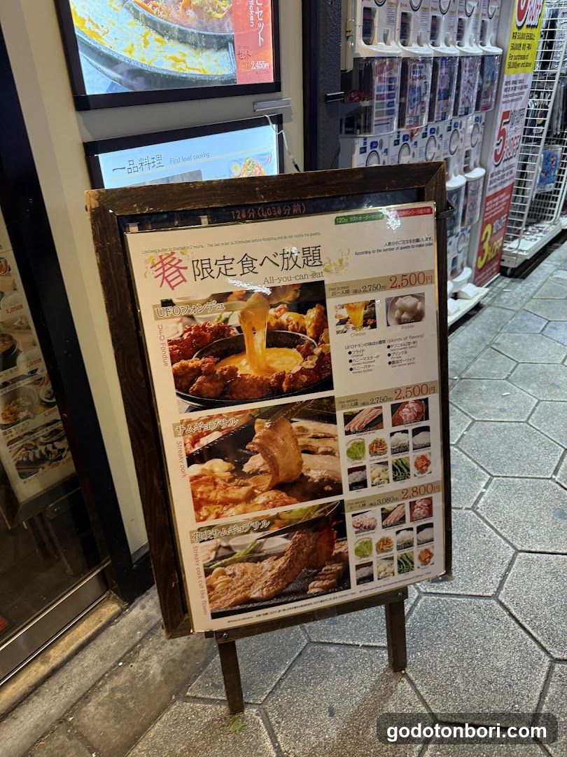 A wooden-framed menu board displaying spring-themed food promotions with prices and images of dishes like chicken, pork, beef, and rice.