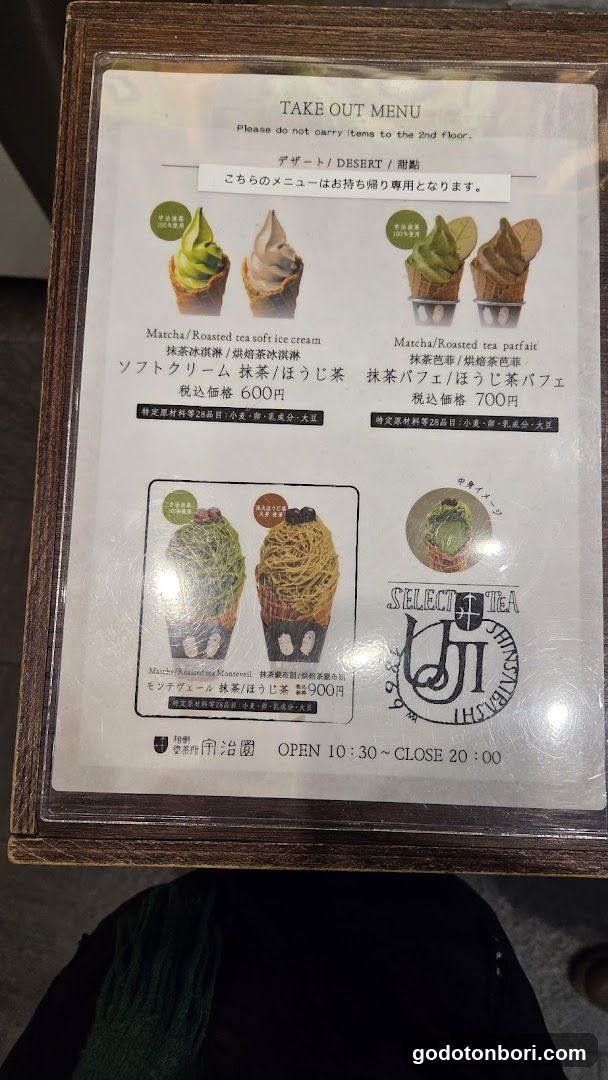 A framed take-out menu from a tea shop, featuring matcha and roasted tea soft-serve ice cream, parfait, and a selection of matcha-based desserts.