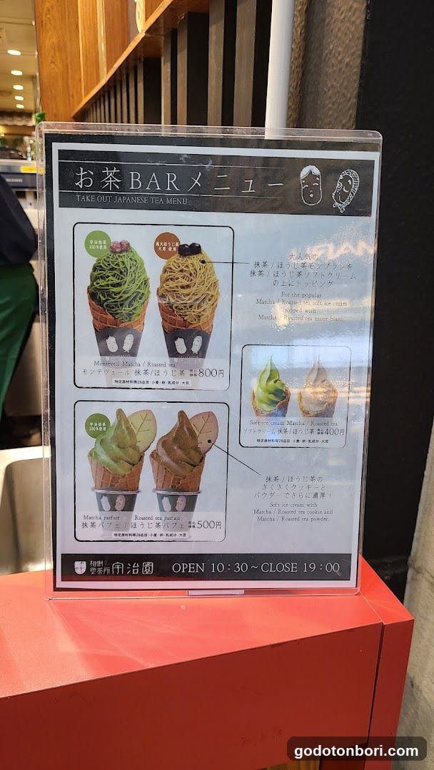 A menu board displaying various tea-flavored ice cream desserts, including Matcha and Hojicha flavors in cone-shaped containers.