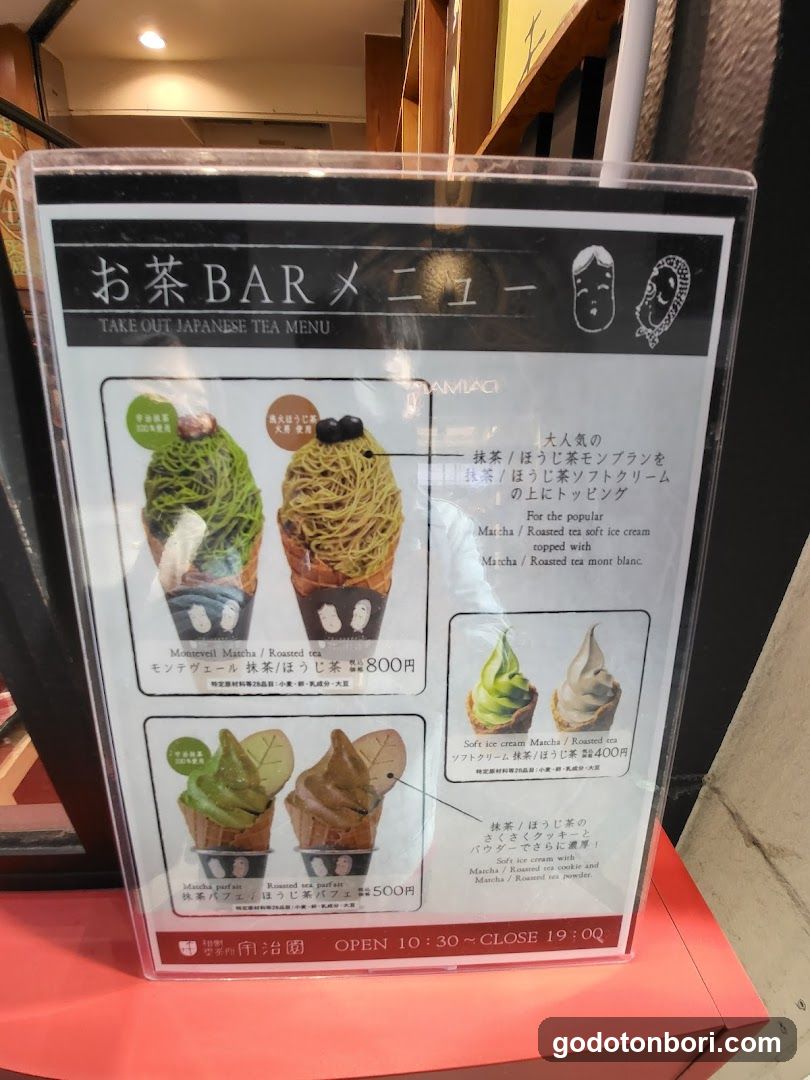 A clear acrylic menu board displaying Japanese tea ice cream options with prices and descriptions in both Japanese and English.