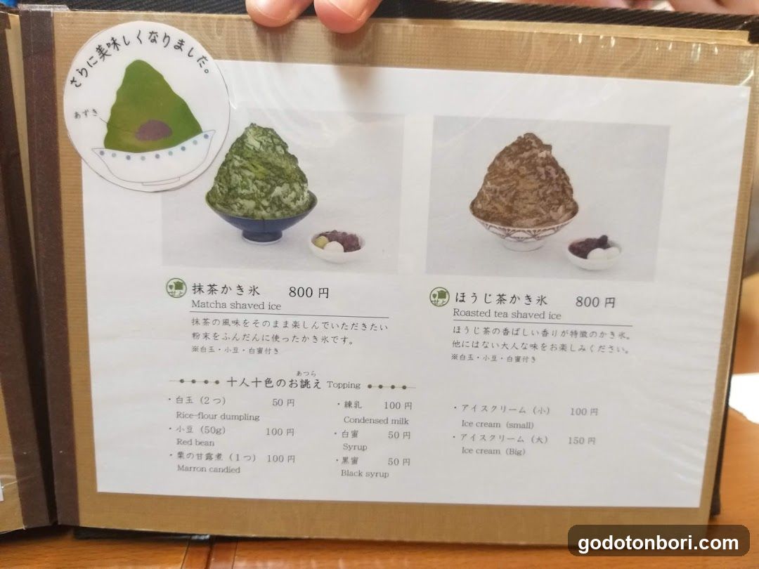 A printed menu page featuring two shaved ice desserts with prices, toppings list, and Japanese text descriptions.