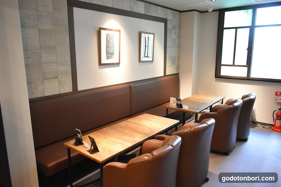 Interior seating area with wooden tables and brown leather chairs