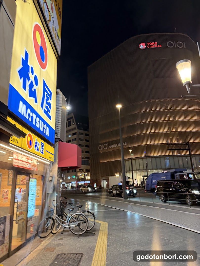 Night street scene with shop and cinema