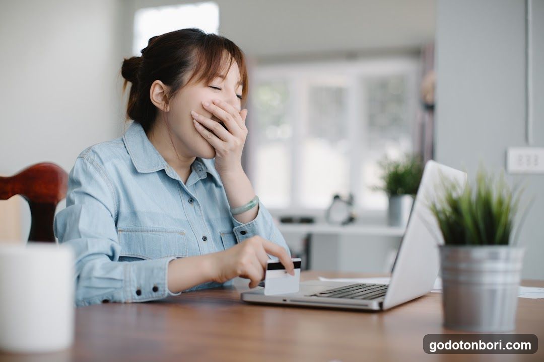 Woman Using Credit Card at Laptop