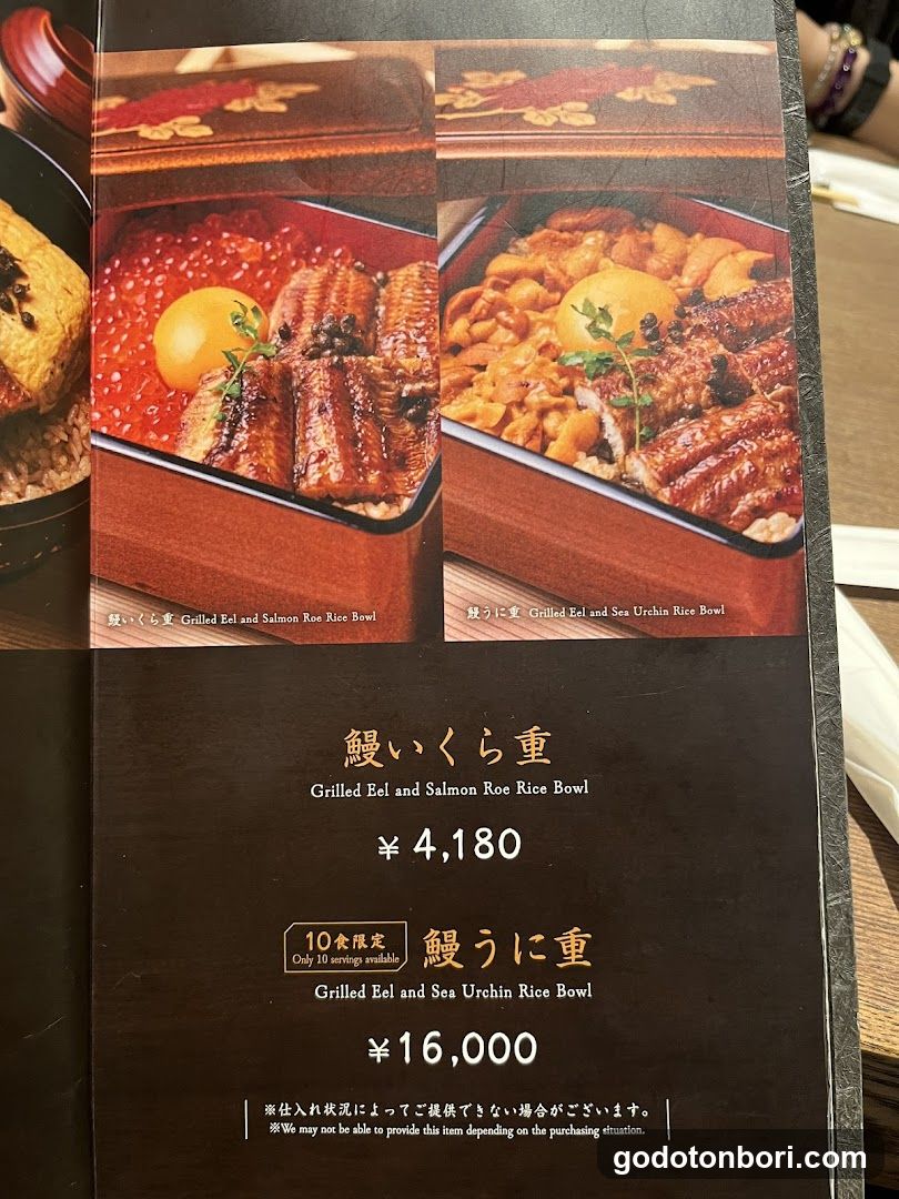 A close-up of a Japanese restaurant menu page featuring two rice bowl dishes with eel, salmon roe, and sea urchin. The menu includes prices in yen and mentions limited availability for one item.