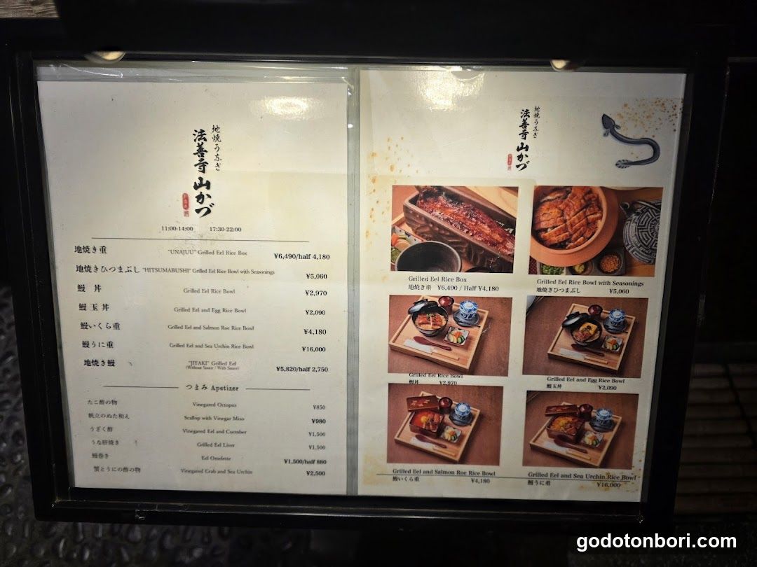 A framed menu board displaying Japanese sake and grilled food items with prices in yen.