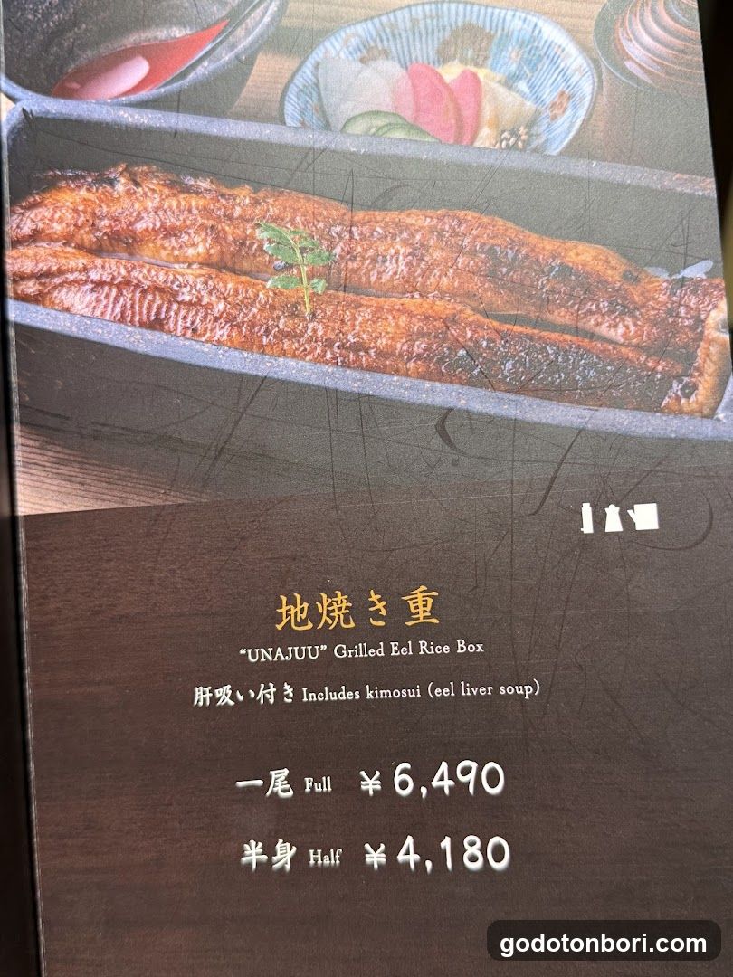 A menu page featuring a photo of grilled eel in a rectangular dish with garnish, alongside text describing the item and prices.