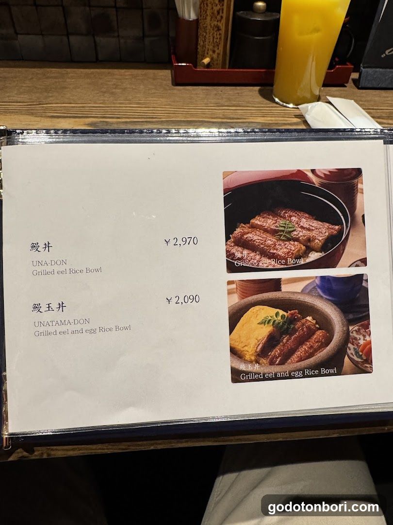A close-up of a menu page featuring two eel rice bowl dishes with prices and images.