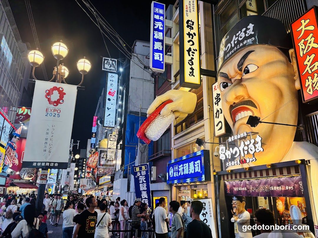 Night street scene with crowds and illuminated signs
