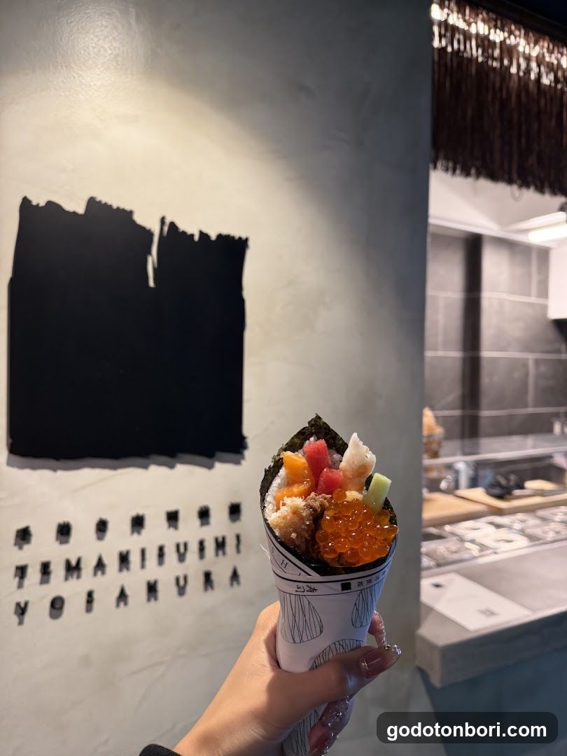 Hand holding sushi cone in restaurant interior