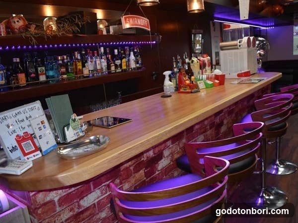 Bar Interior with Wooden Counter and Purple Lighting