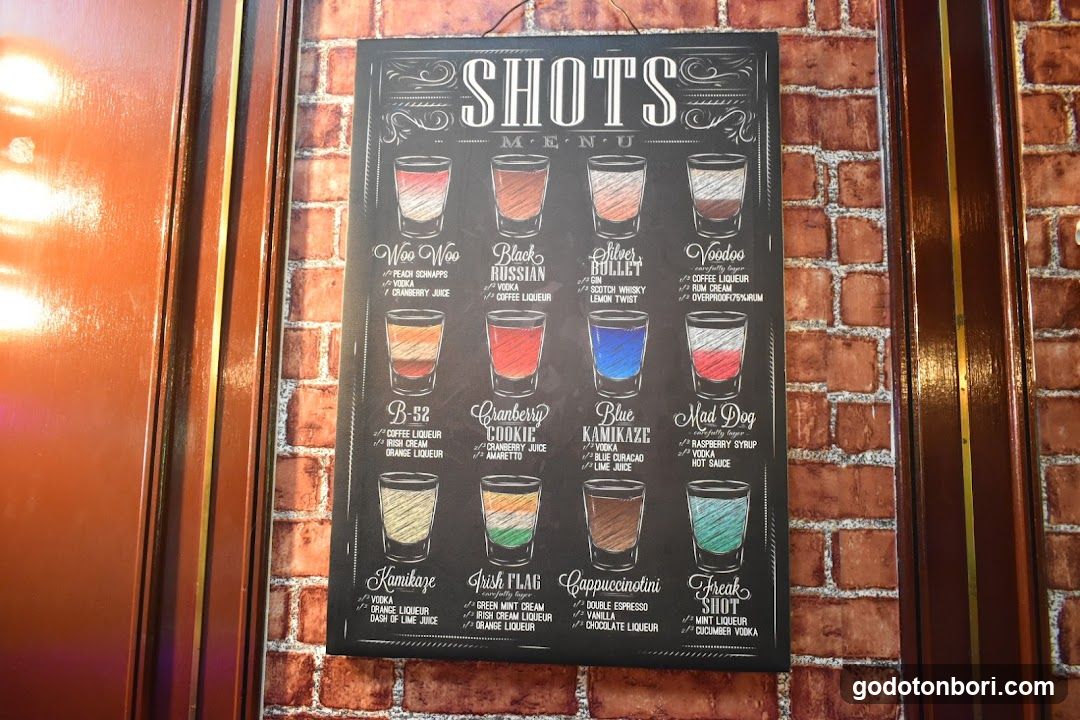 A chalkboard menu displaying various shots with illustrations of glasses and ingredient lists.