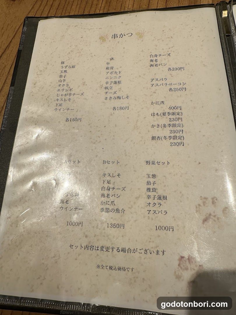 A menu board displaying various types of yakitori and sets, including options like 'Uzu Soba', 'Yamabuki', 'Asparagus', and seasonal items.