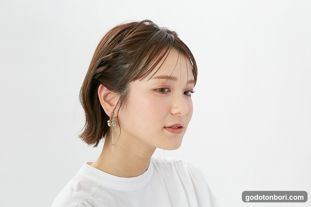 Portrait of a woman with short brown hair and dangling earrings