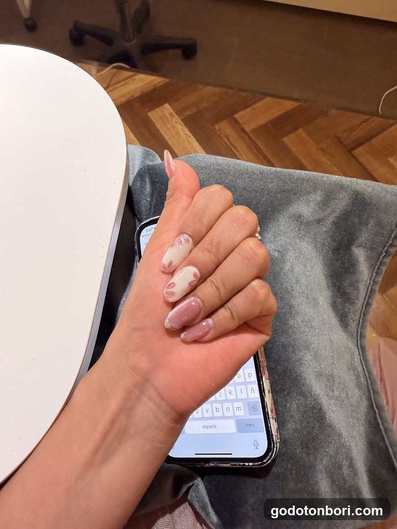 Hand with manicured nails resting on phone
