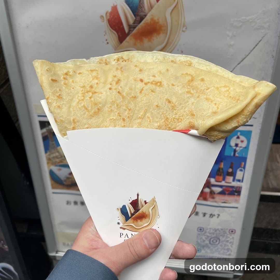 Hand holding a crepe in paper cone
