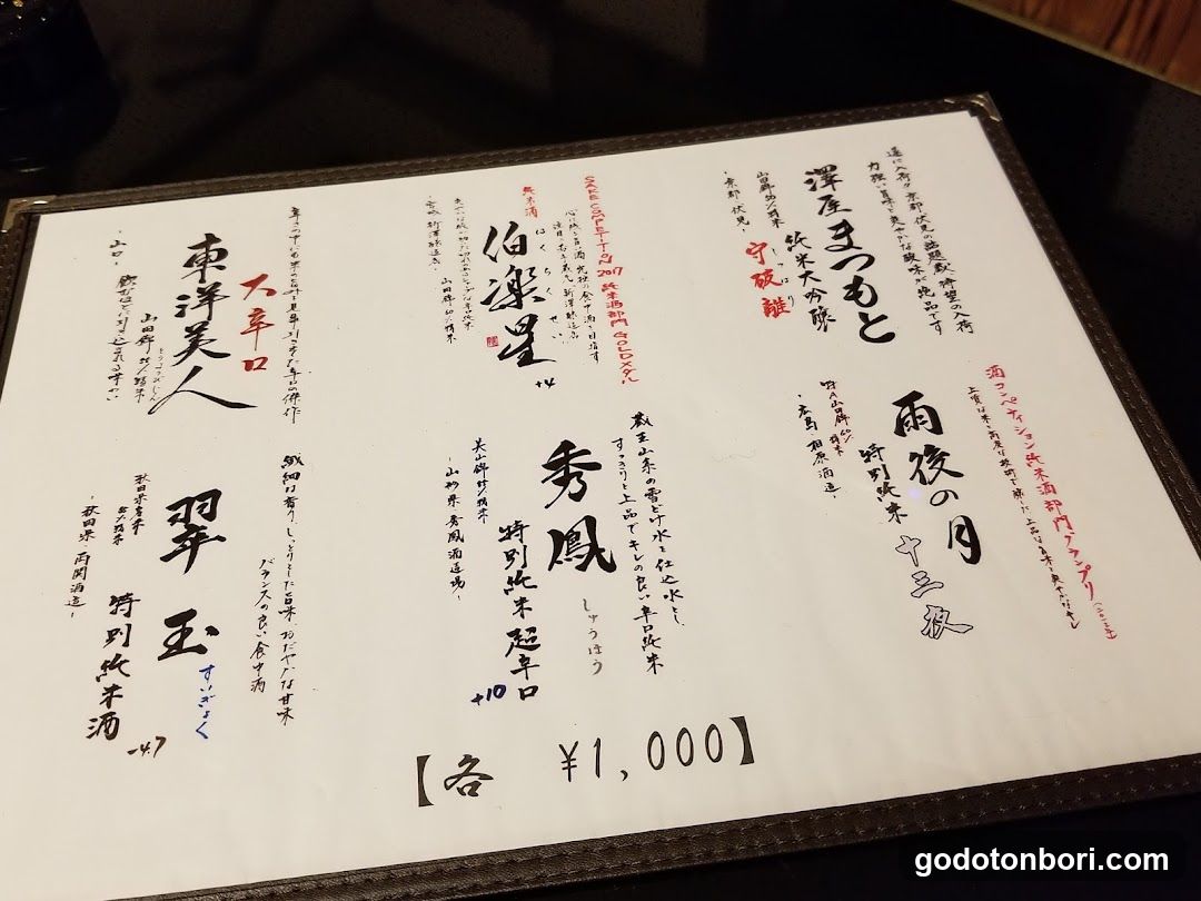 A printed menu featuring various sake options with Japanese calligraphy-style text and prices.