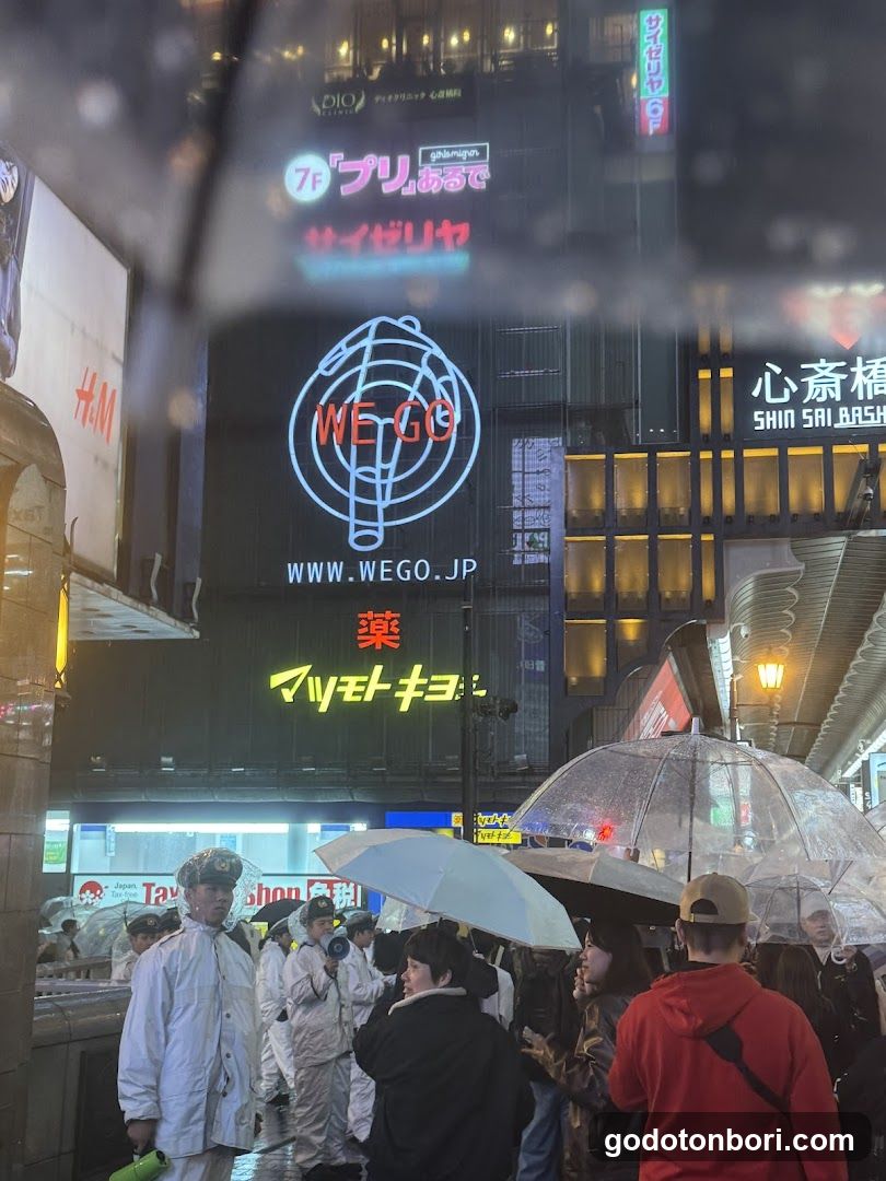 Night street scene with crowd and umbrellas