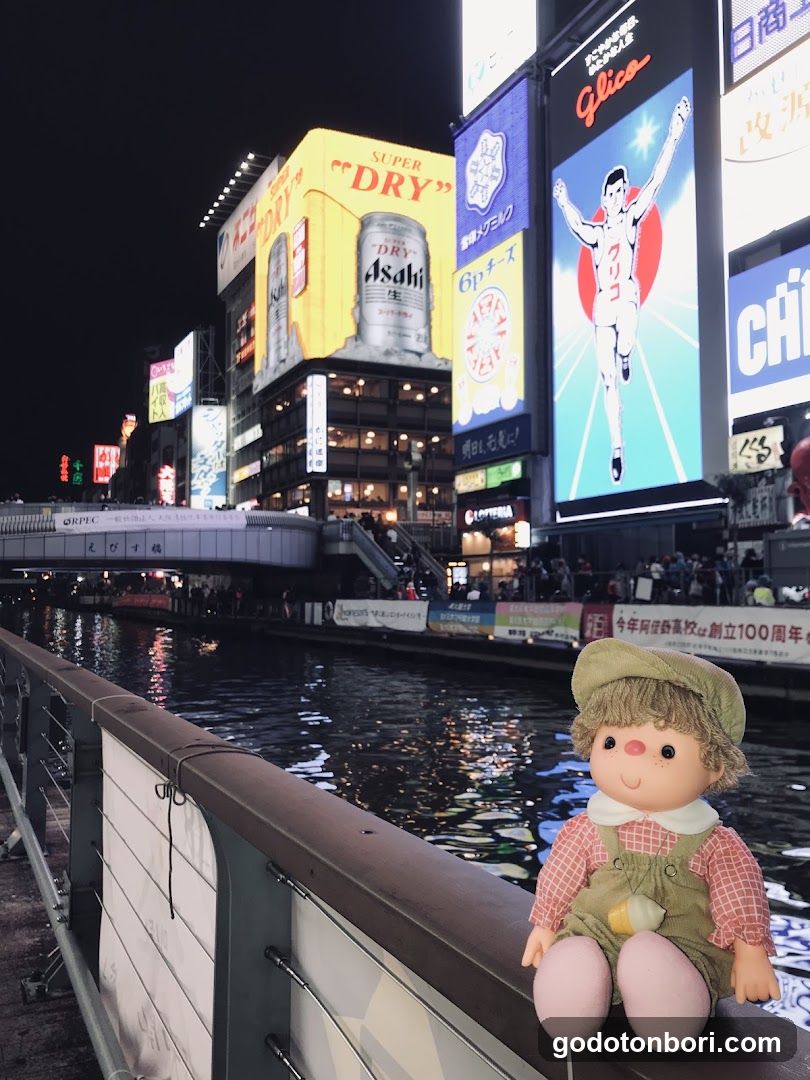 Night scene with neon signs and a doll