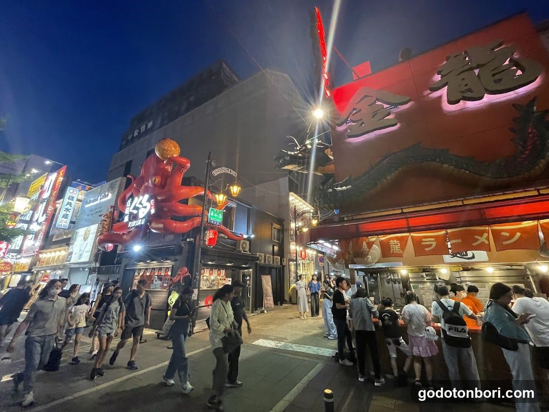 Night street scene with crowds and illuminated signs