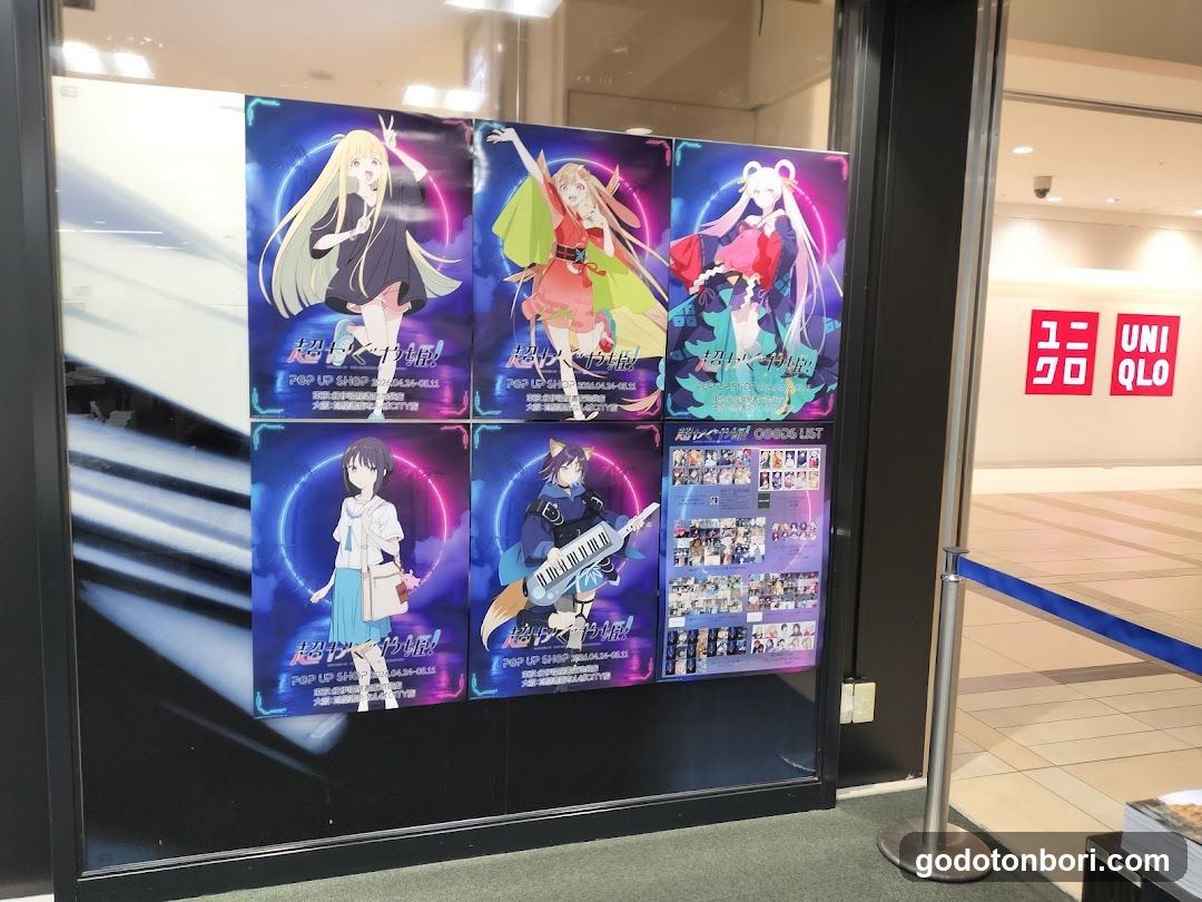 A storefront display featuring six anime-style character posters arranged in a grid on the glass window of a shop. The characters are depicted in vibrant colors against glowing circular backgrounds. To the right, red square signs with white text reading 'UNIQLO' are visible on the wall inside the store. A blue retractable belt barrier is set up near the entrance. The interior shows tiled flooring and recessed ceiling lights.