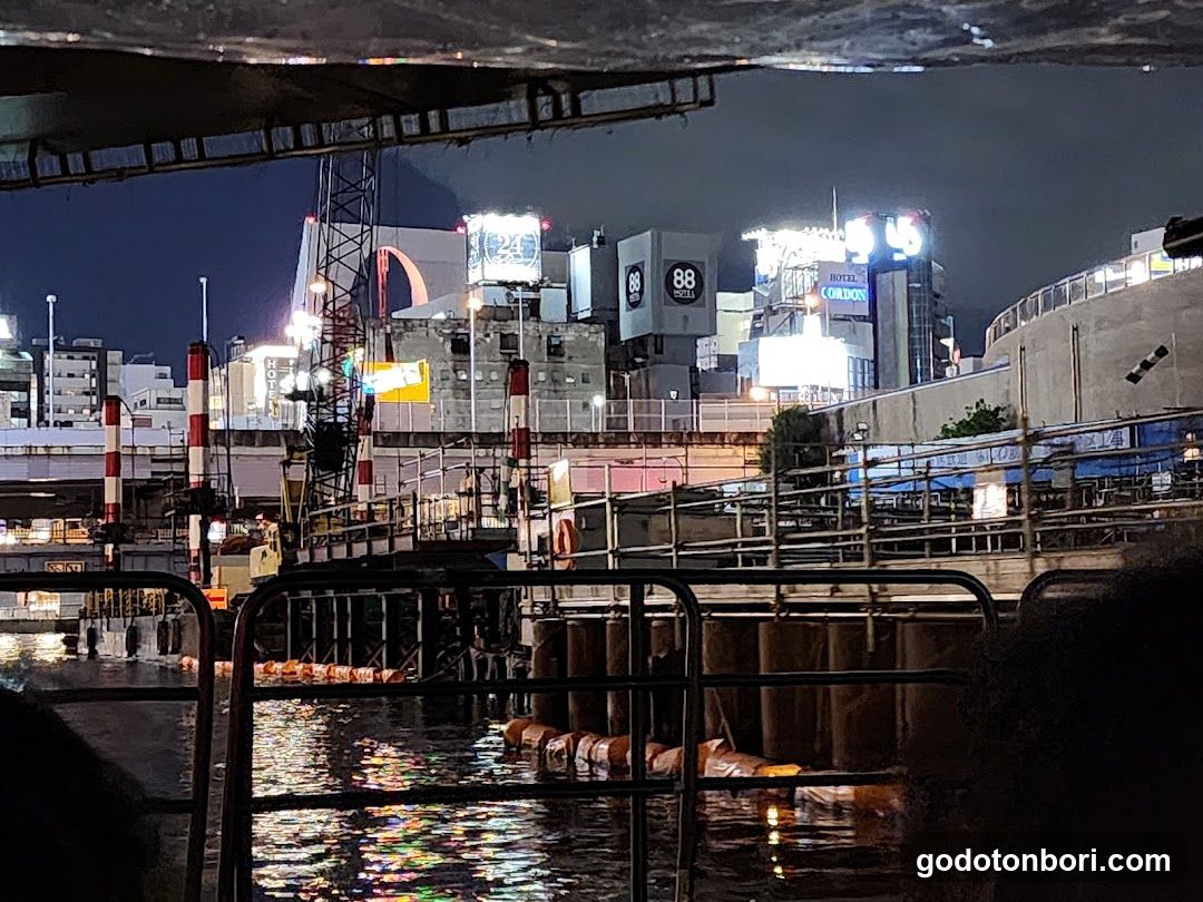 Night view of a waterfront area with illuminated buildings and structures.