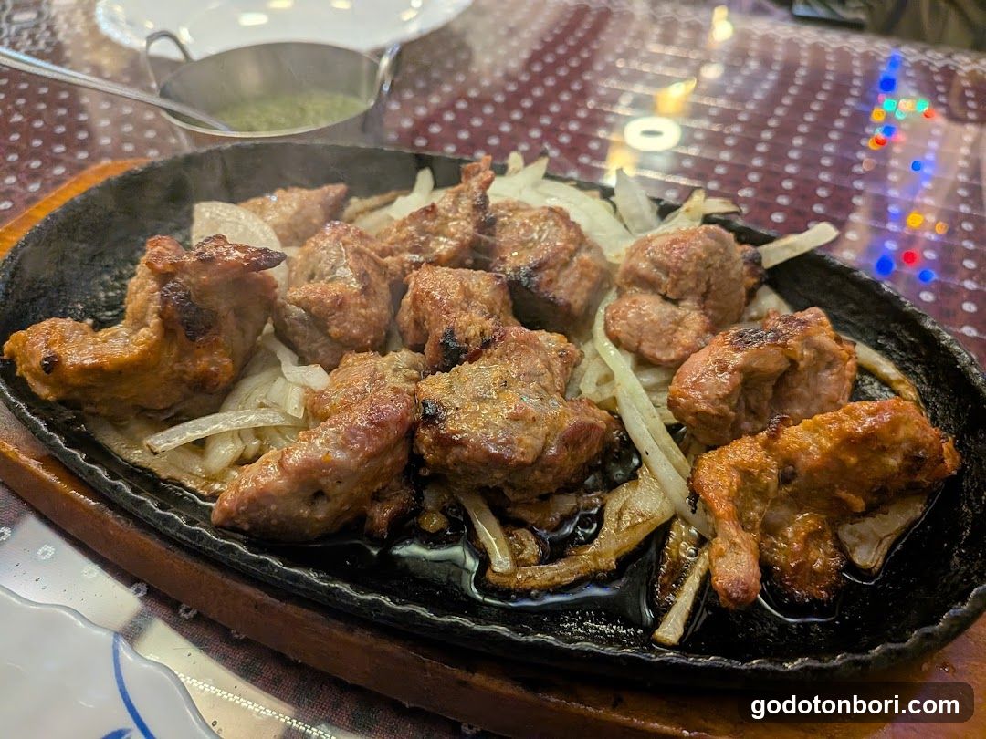 Sizzling Meat and Onions on a Hot Plate
