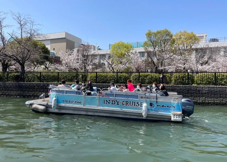 Passengers boarding an open-air Tombori River cruise boat in Dotonbori