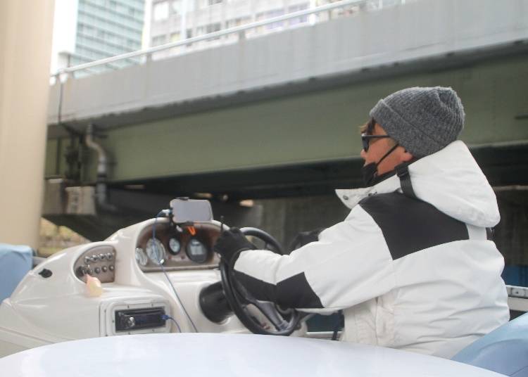 Tombori River cruise passing under low bridges along Dotonbori canal in Osaka