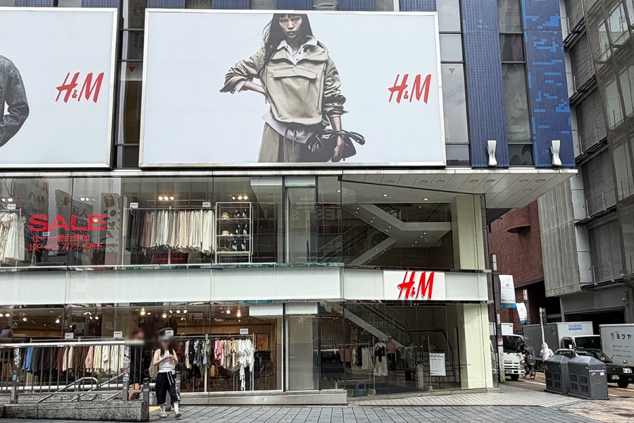 H&M Ebisubashi storefront at night along the Dotonbori riverwalk