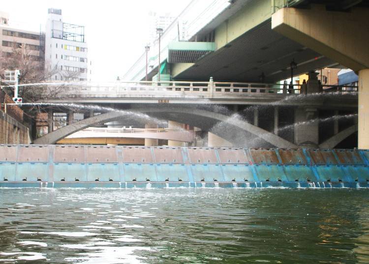 Dotonbori canal at night with neon signs reflecting off the water in Osaka